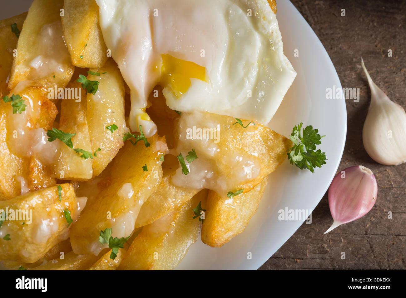 Hausgemachte Pommes Frites (Kartoffeln) mit Knoblauchsauce und Ei auf hölzernen rustikalen Hintergrund Stockfoto