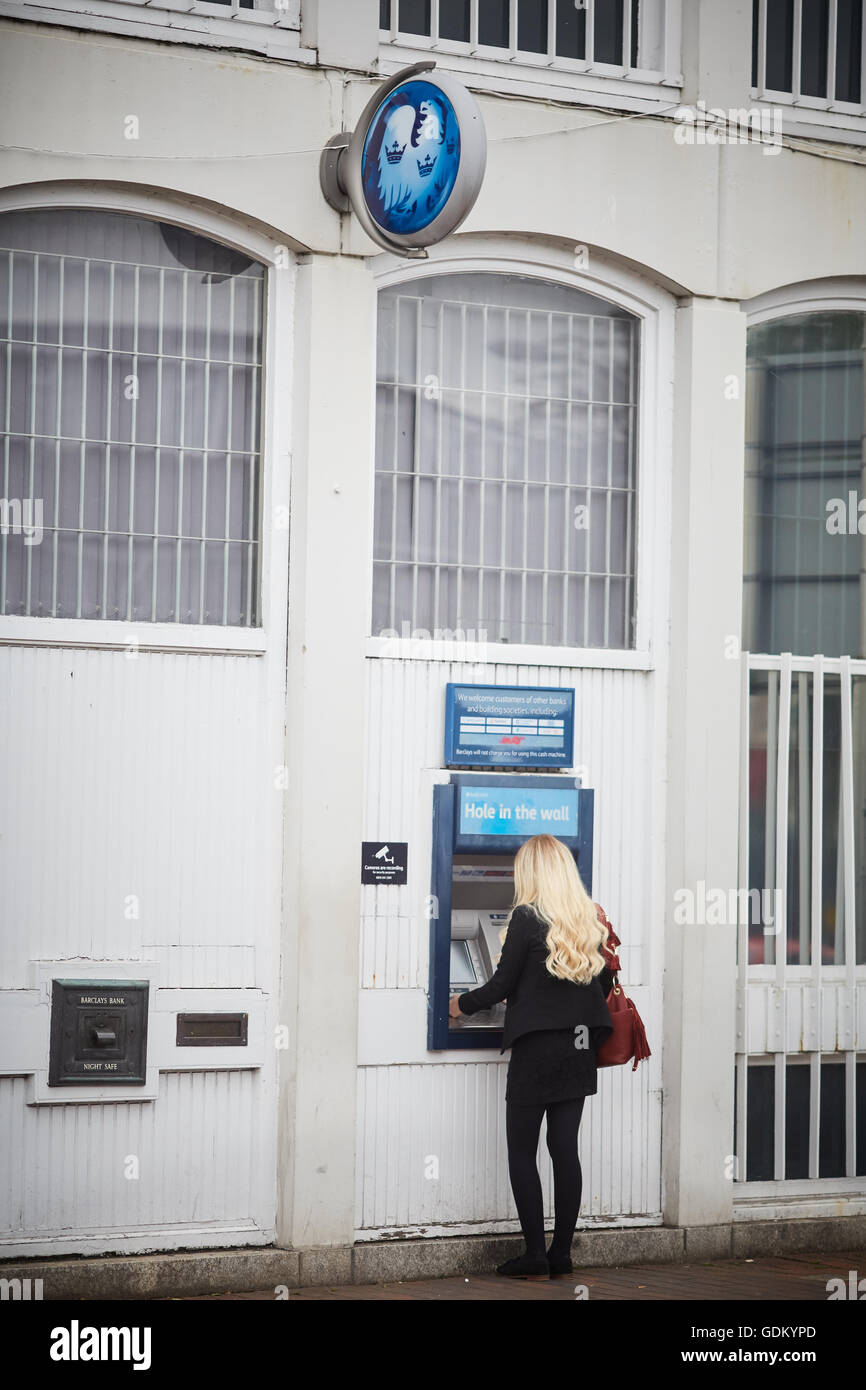 Wilmslow Barclays bank Geldautomat atm junge Dame Mädchen Frau sie mit Geldautomaten in der Stadt Straße Zentrum einzelne Nachttresor de Stockfoto