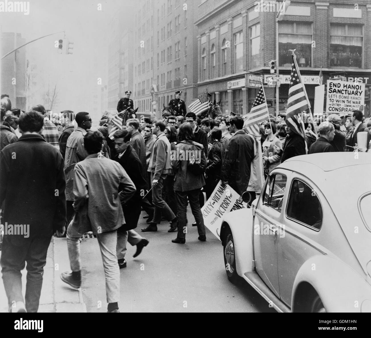 Demonstranten marschieren in einer Innenstadt mit Fahnen und Plakate zur Unterstützung des Krieges in Vietnam, Polizei auf dem Pferderücken im Hintergrund. Foto von Matthew Black. Stockfoto