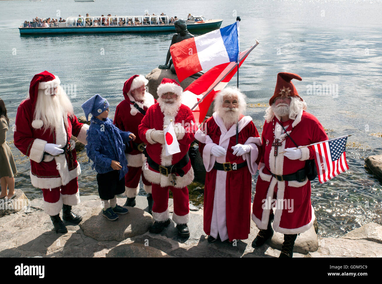 Kopenhagen, Dänemark – 18. Juli 2016: Santa Claus Teilnahme an der World Santa Claus Kongress 2016 besucht die Hafenpromenade Langelinie, wo die Skulptur der kleinen Meerjungfrau platziert wird. Auf dem Foto sind Santa aus USA, Frankreich, Japan und Kanada. Der Kongress statt findet seit 1957. Der Veranstaltungsort und Veranstalter ist Bakken, der älteste Vergnügungspark der Welt und befindet sich nördlich von Kopenhagen. Bildnachweis: OJPHOTOS/Alamy Live-Nachrichten Stockfoto