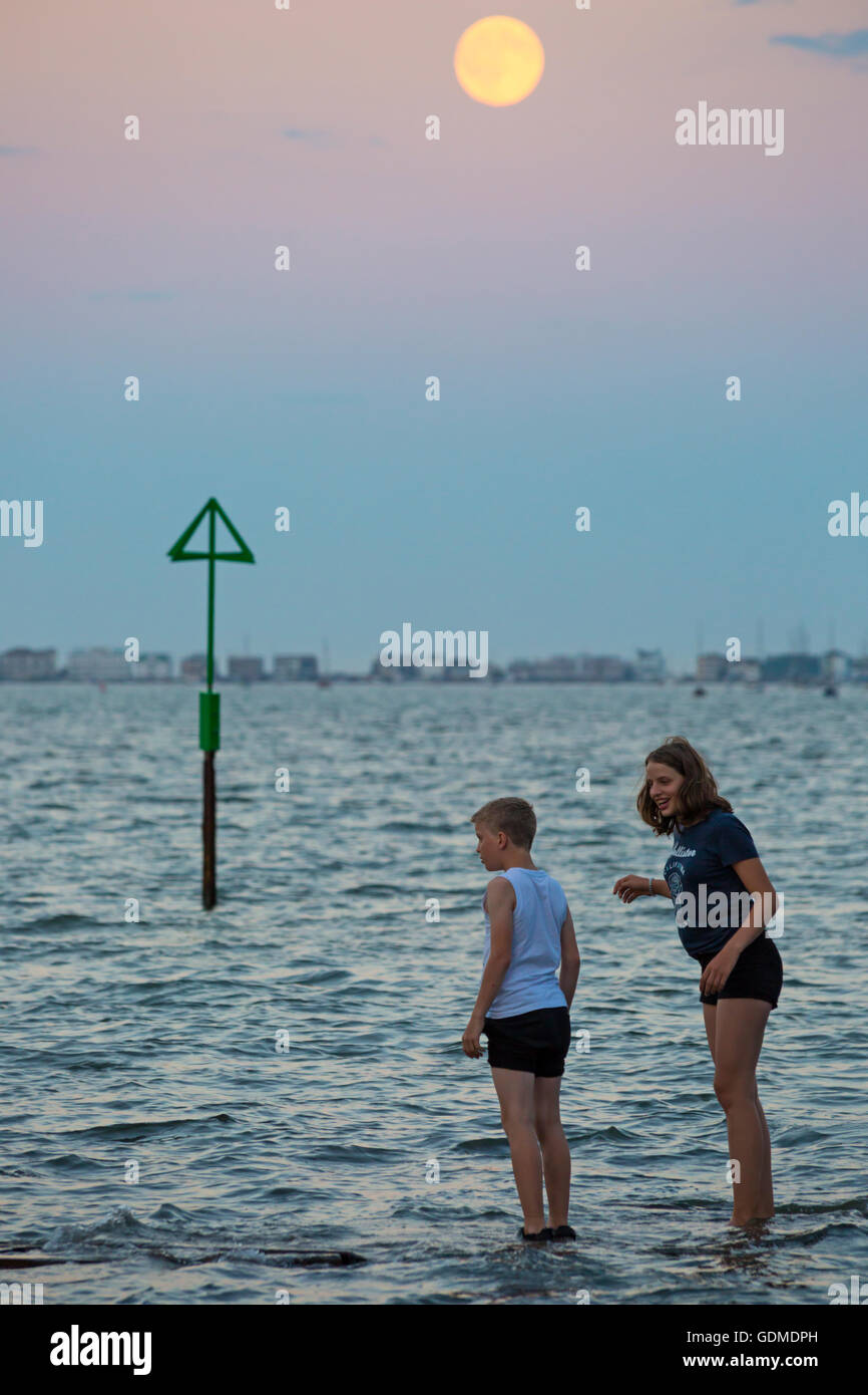 Poole, Dorset, UK. 19. Juli 2016 UK Wetter: Vollmond über Poole Bay am heißesten Tag des Jahres Blick auf Sandbänken - Kinder Paddel kühl zu halten, da Temperaturen in der Nacht Credit hoch bleiben: Carolyn Jenkins/Alamy Live News Stockfoto