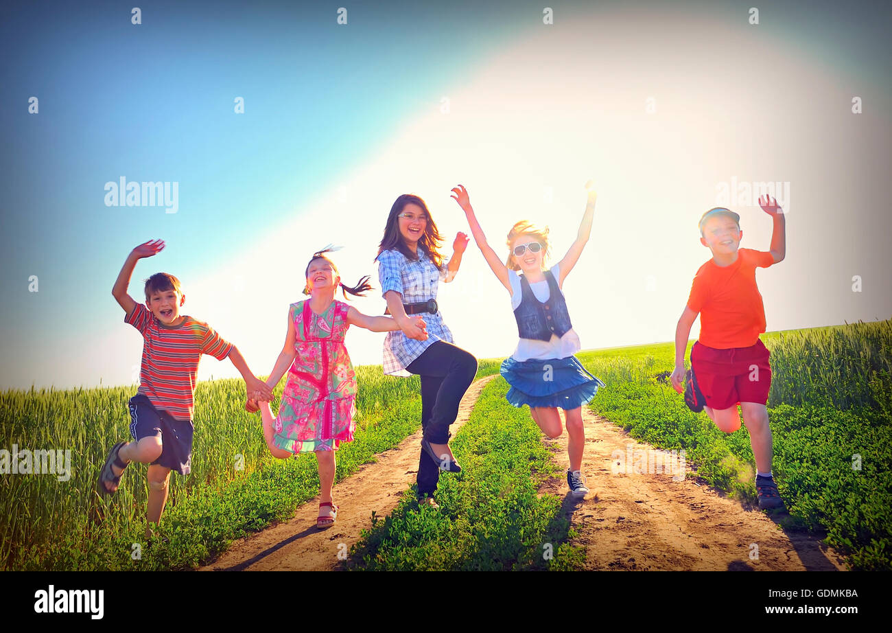 glückliche Kinder spielen auf Feld im Sommer Stockfoto