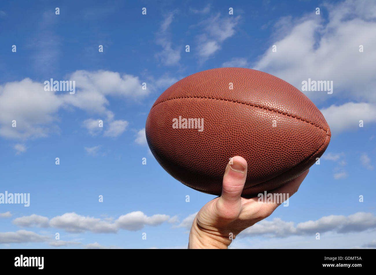 Quarterback wirft ein American Football vor blauem Himmel Stockfoto