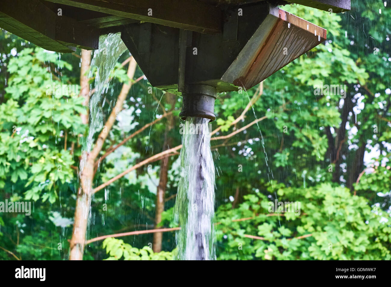 Große Menge an Wasser aus einen Anführer Kopf eine Kette von Metallringen durch Starkregen Stockfoto
