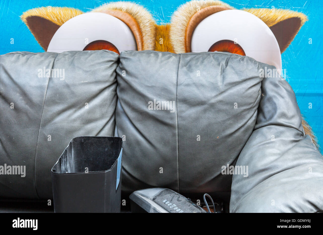 Cartoon-Augen spähte über eine alte Couch auf einem Bürgersteig NYC geworfen Stockfoto
