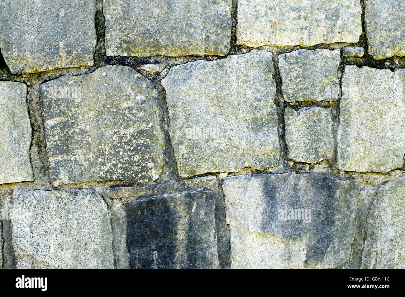 Nahaufnahme von einem grauen geschliffenen Stein Wand Hintergrund mit unregelmäßigen Formen Stockfoto