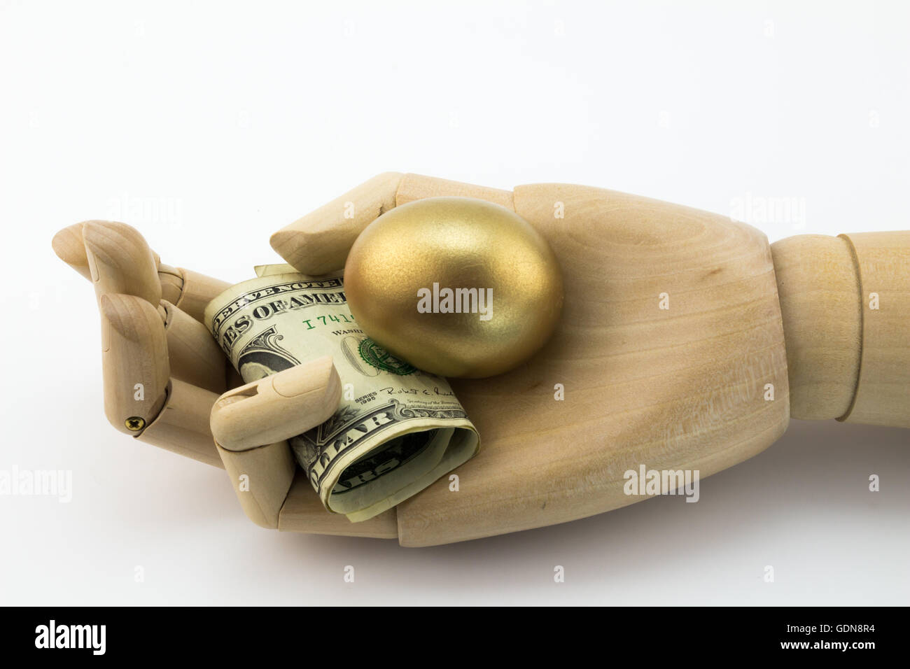 Goldene Notgroschen in hölzernen Handfläche mit Dollarnoten Stockfoto