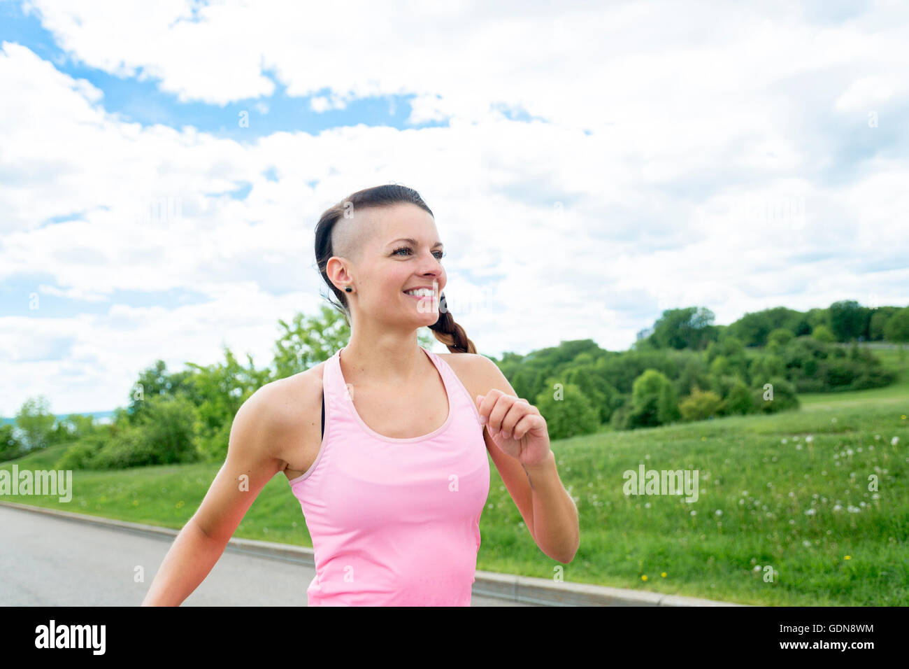 sportliche Frau, die im Freien im Park laufen Stockfoto