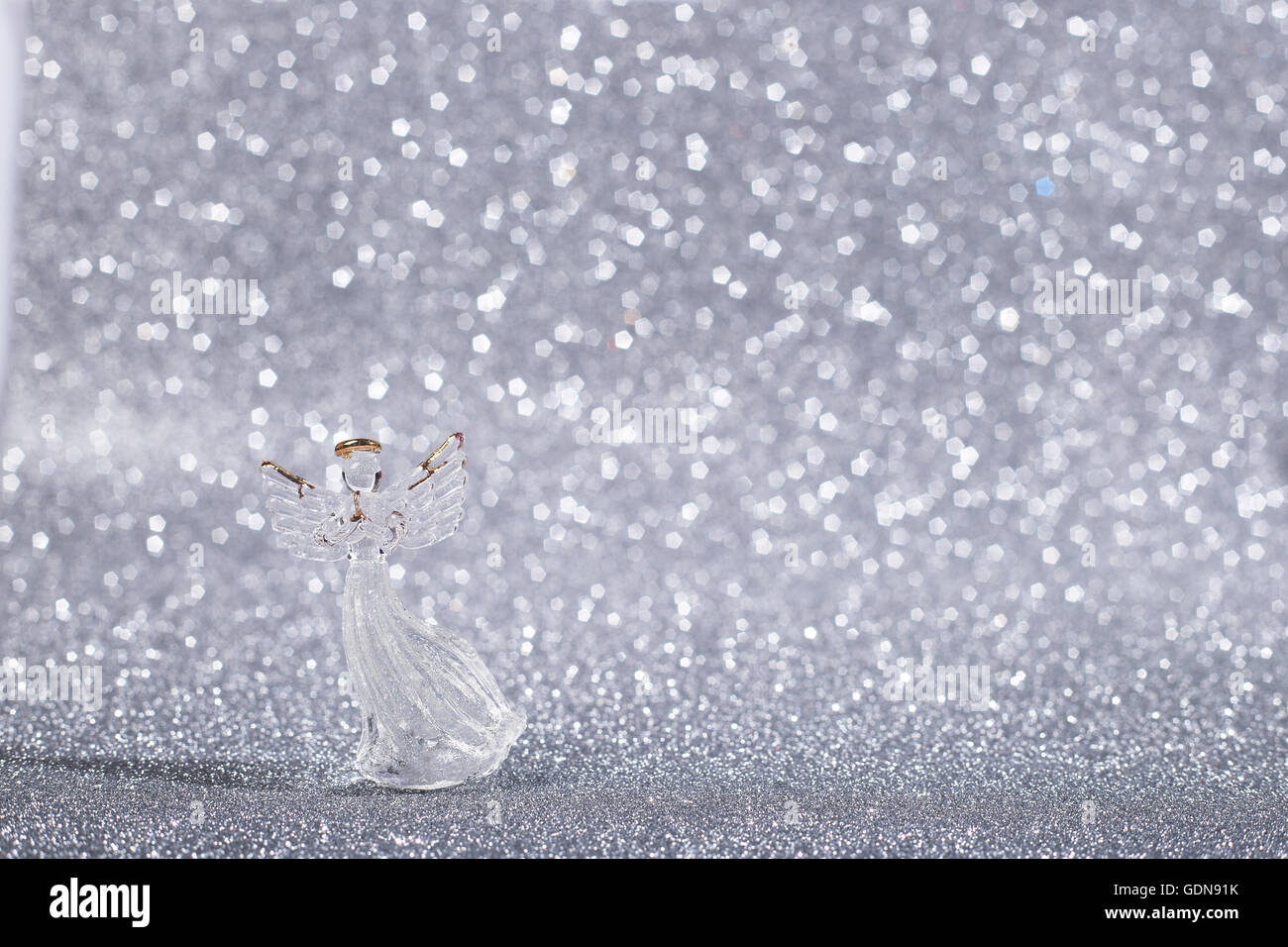 Weihnachtsengel auf Silber glänzend Glitzer Hintergrund mit Textfreiraum Stockfoto