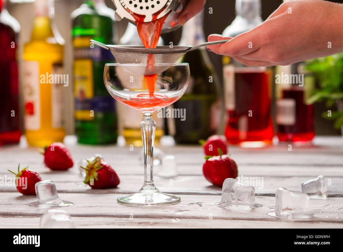 Rote cocktail gießt durch Sieb. Stockfoto