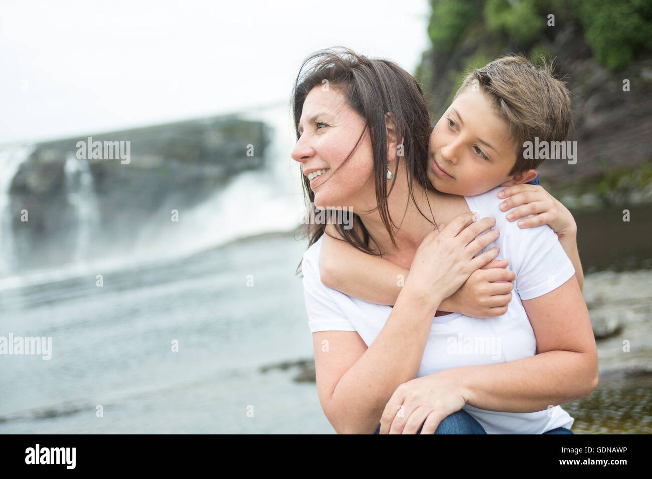 Mutter und Sohn vor einem Wasserfall zu spielen Stockfoto