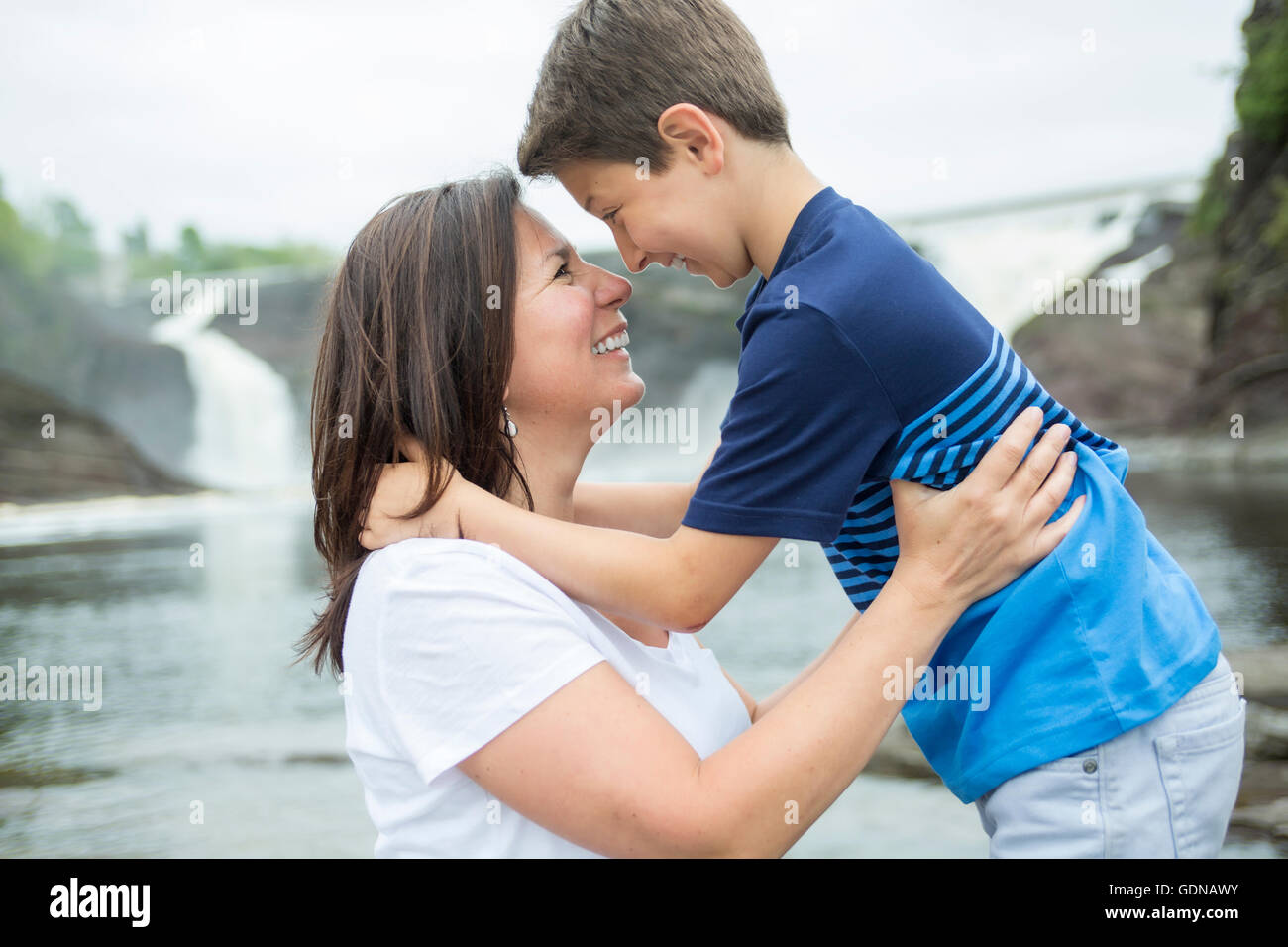 Mutter und Sohn vor einem Wasserfall zu spielen Stockfoto