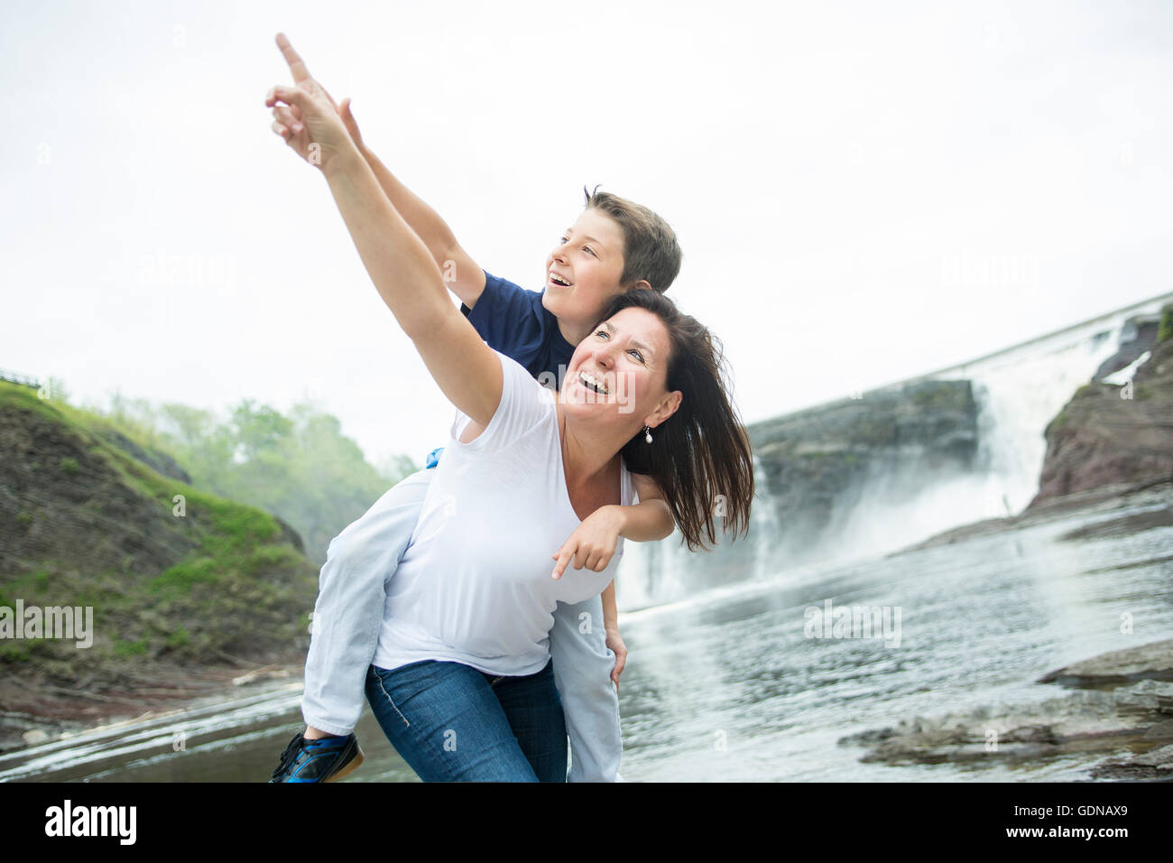 Mutter und Sohn vor einem Wasserfall zu spielen Stockfoto