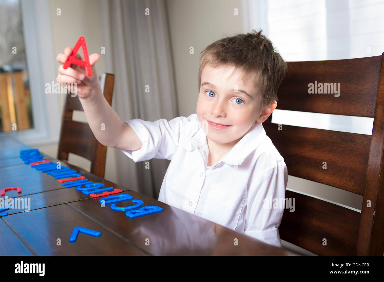 Junge nach Hause mit Buchstaben lernen Stockfoto