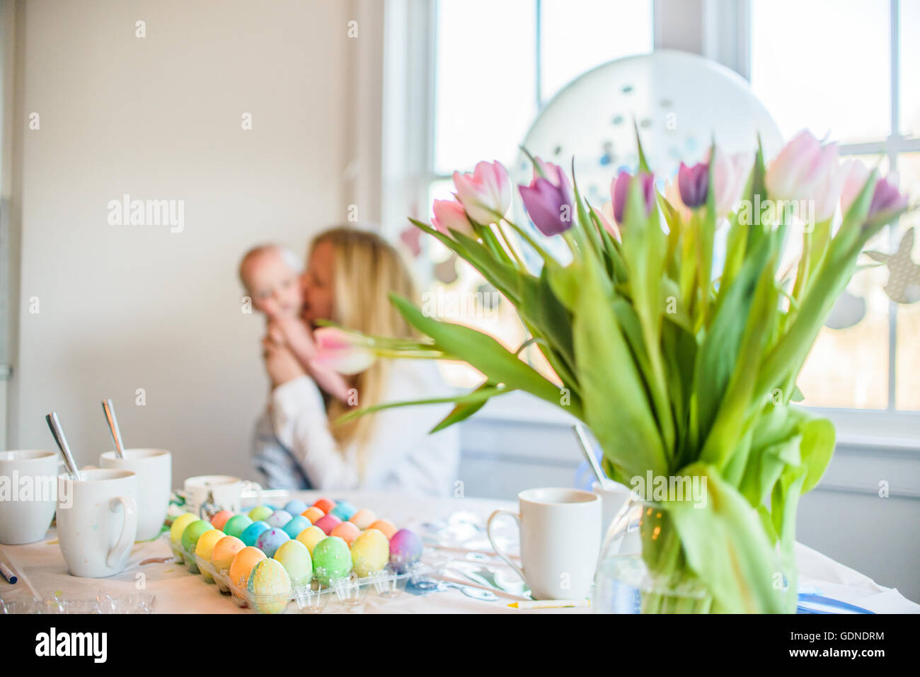 Gefärbte Ostereier auf Tisch vor Mutter und Baby Sohn zu Ostern Stockfoto