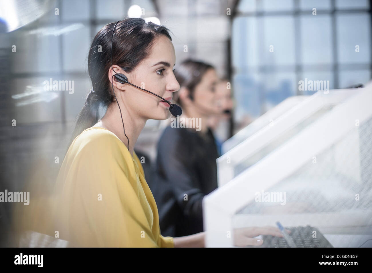 Reihe von weiblichen Telefonisten Beratung im Call-Center Stockfoto
