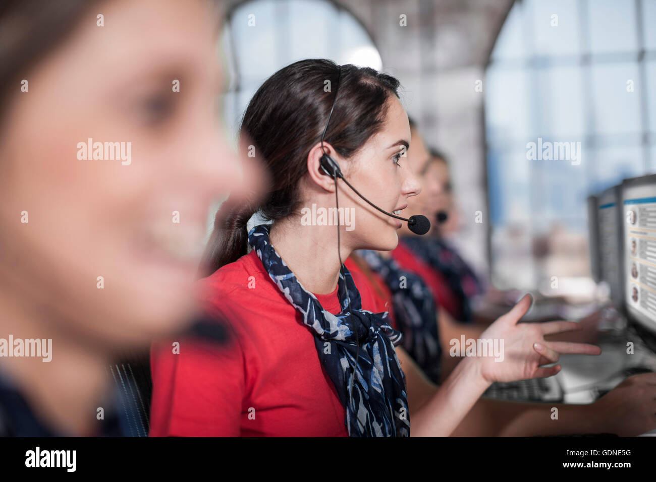 Reihe von weiblichen Telefonisten, die Arbeit in Callcenter Stockfoto