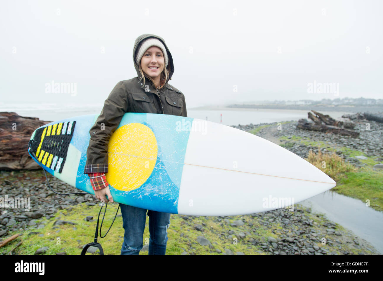 Porträt der weibliche Surfer mit Surfbrett an Küste, Meer, Oregon, USA Stockfoto Porträt der weibliche Surfer mit Surfbrett an Küste, Meer, Oregon, USA Stockfoto