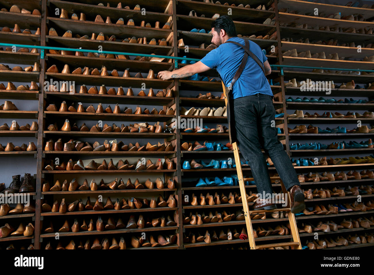 Männlichen Schuster in traditionelle Schuhgeschäft auf Leiter Schuh letzte Auswahl Stockfoto