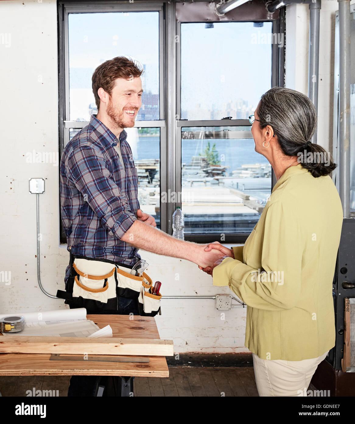 Tischler Händeschütteln mit client Stockfoto