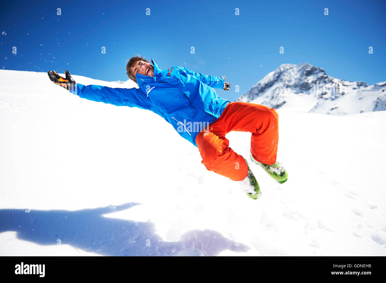 Junge Teenager herumalbern, springen im Schnee Stockfoto