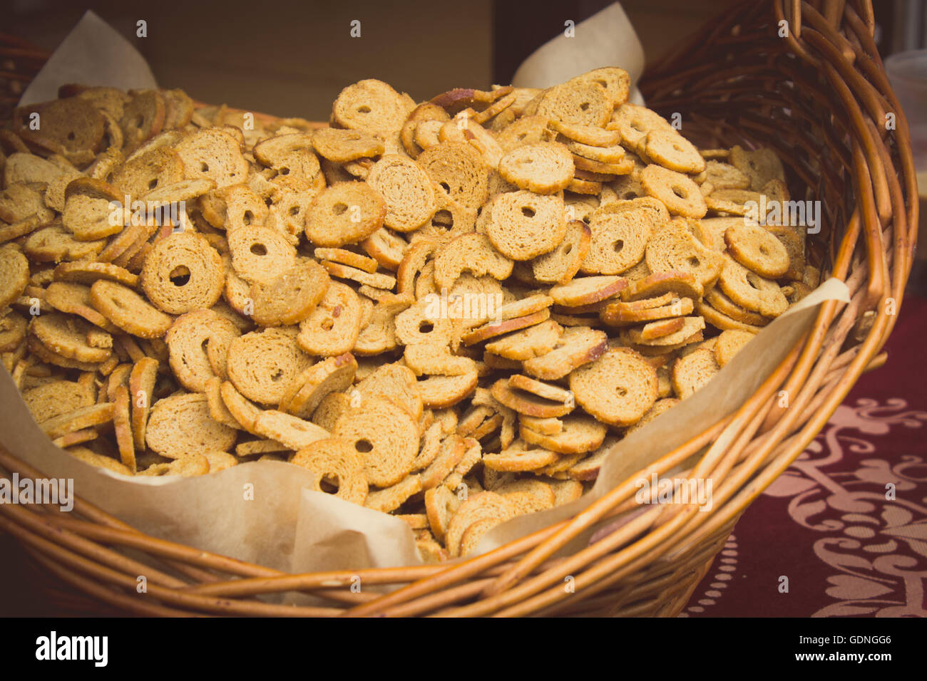 Vintage Foto, frisch gebackene Bagel-Chips im Weidenkorb auf Stall auf dem Basar Stockfoto