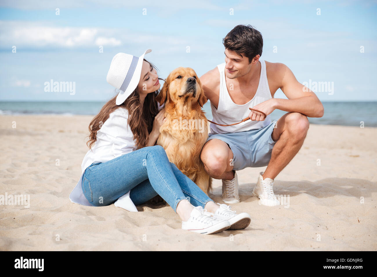 Junge stilvolle schönes paar in Liebe Sitzung spielen mit Hund Stockfoto