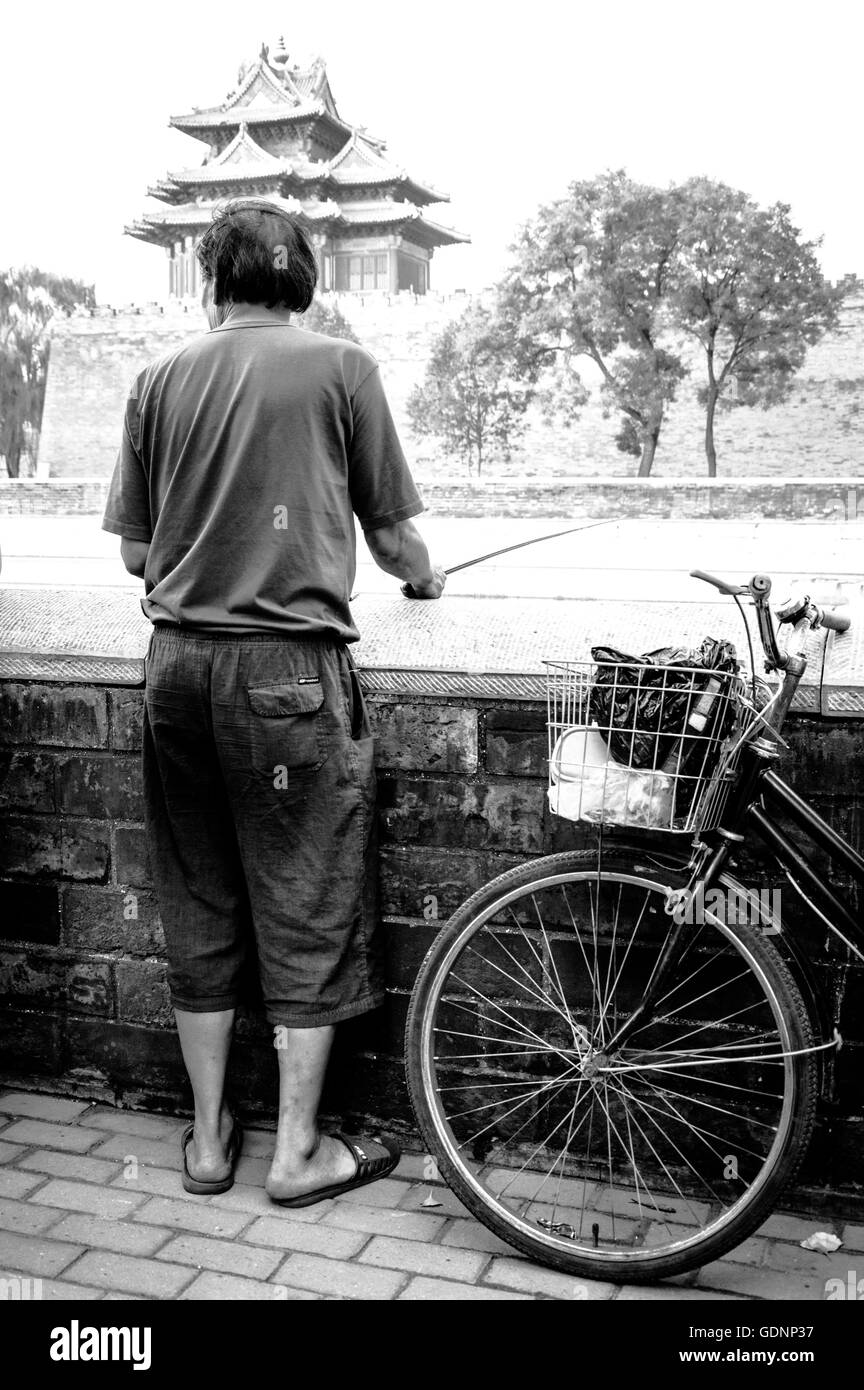 Rückansicht des Mann Angeln mit einem Pol an verbotenen Stadt außen Kanal Stockfoto