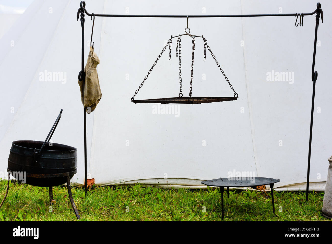 Grill-Rack und outdoor Kochgeräte vor einem weißen Zelt. Stockfoto