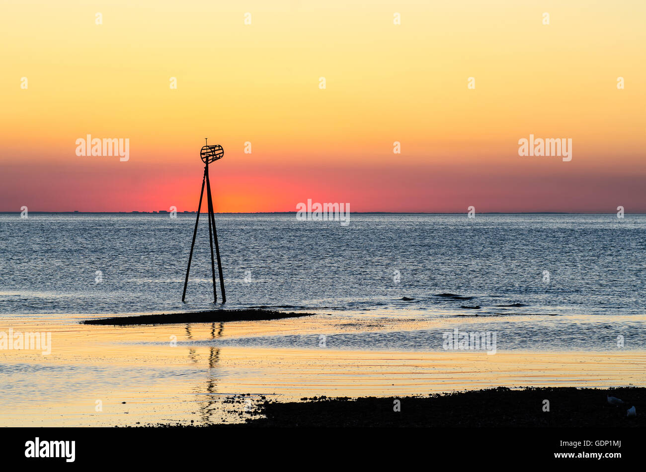 Sonnenuntergang in Hampton, in der Nähe von Herne Bay, Kent, UK. Ein Seezeichen ist durch die Gloow der Sonne abhebt. Stockfoto