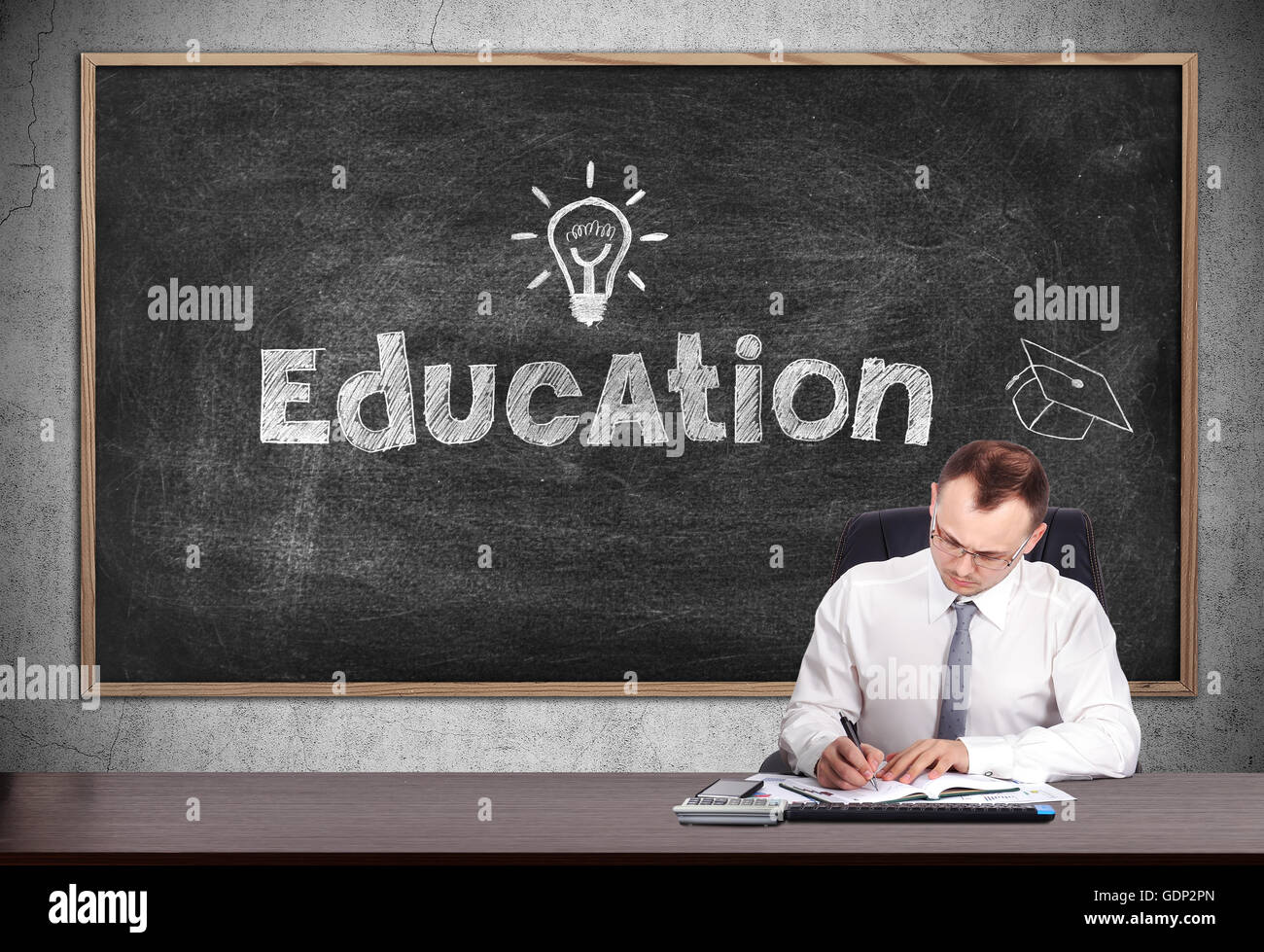 Geschäftsmann unterschreibt einen Vertrag und Tafel mit Bildung Stockfoto