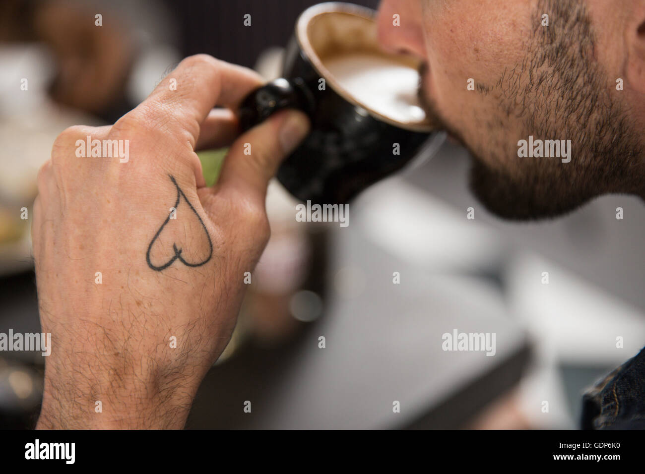 Ansicht der tätowierte Mann Kaffeetrinken beschnitten Stockfoto