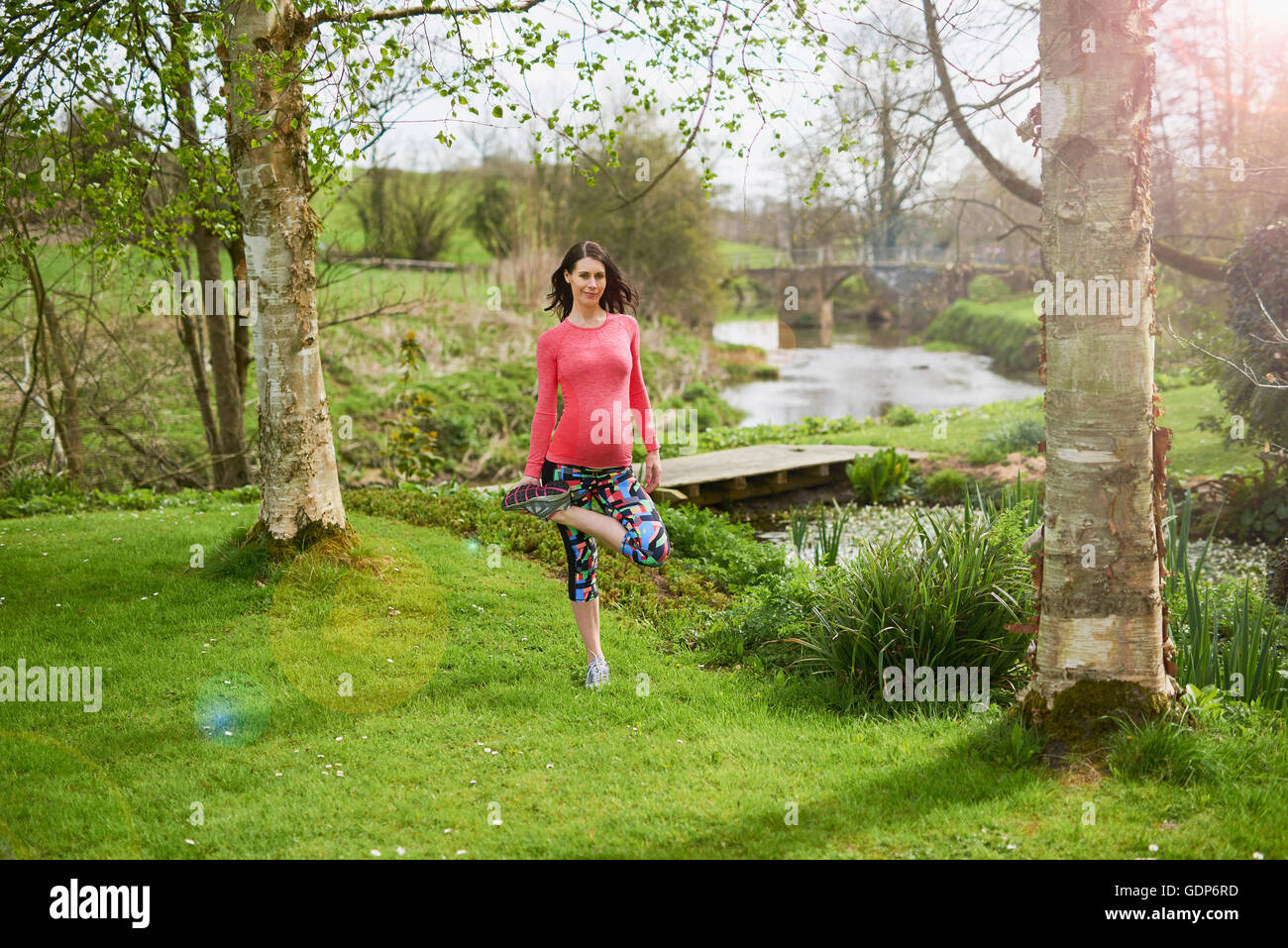 Schwangere Frau im Freien, in Yogaposition Stockfoto