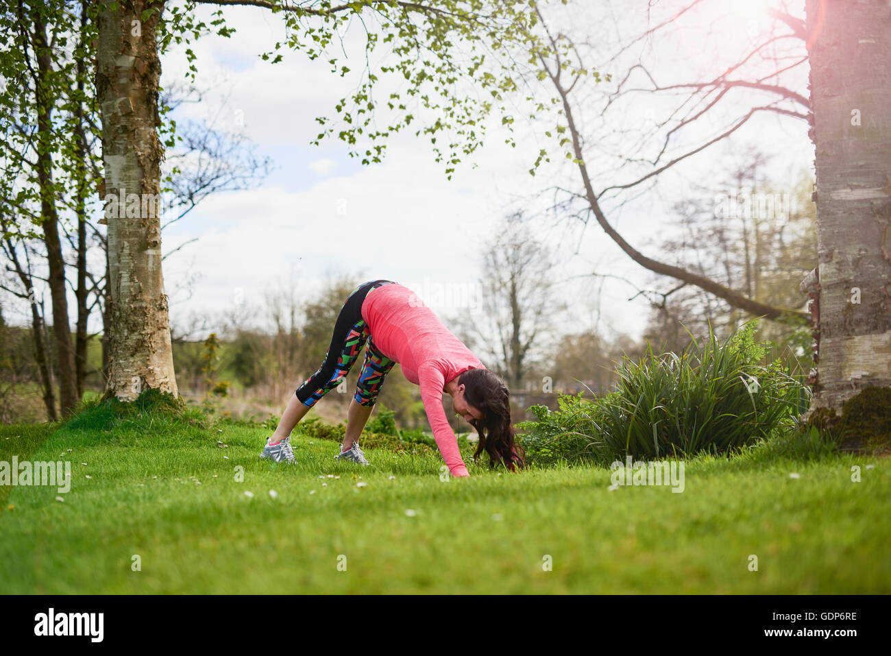 Schwangere Frau im Freien, in Yogaposition Stockfoto