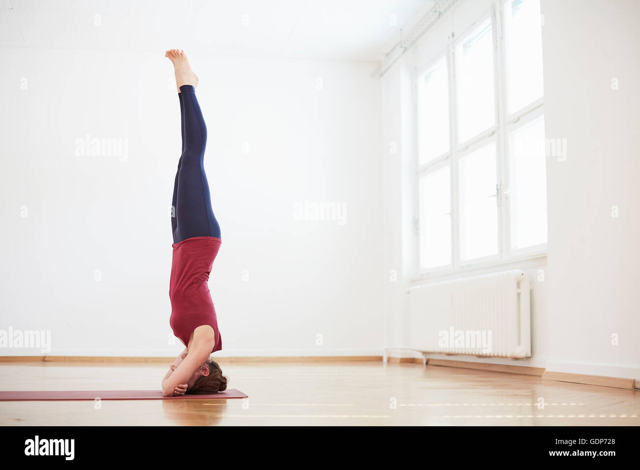 Frau in Übung Studio macht Kopfstand Stockfoto