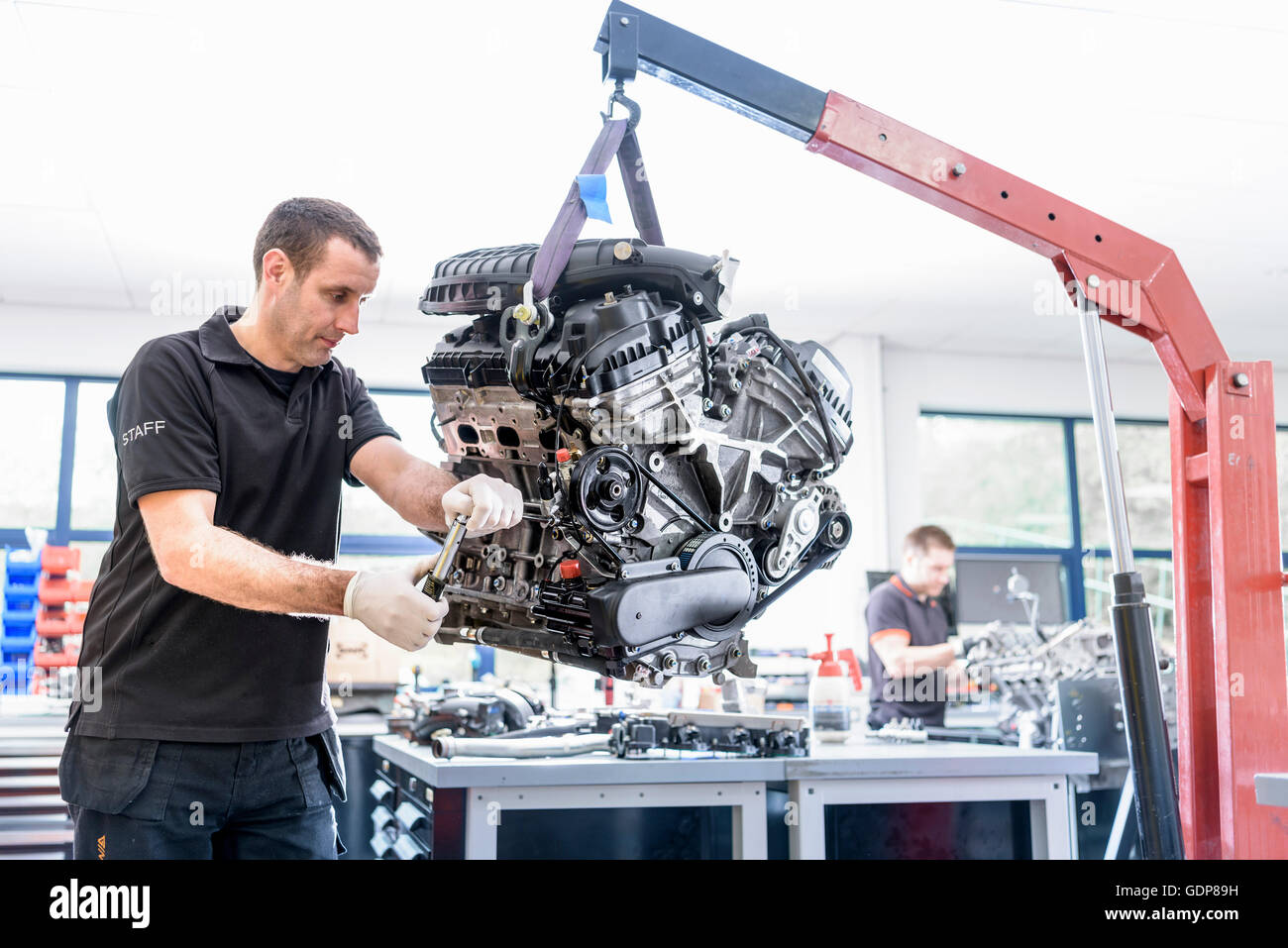 Ingenieure arbeiten an Motoren im Rennsport Autofabrik Stockfoto