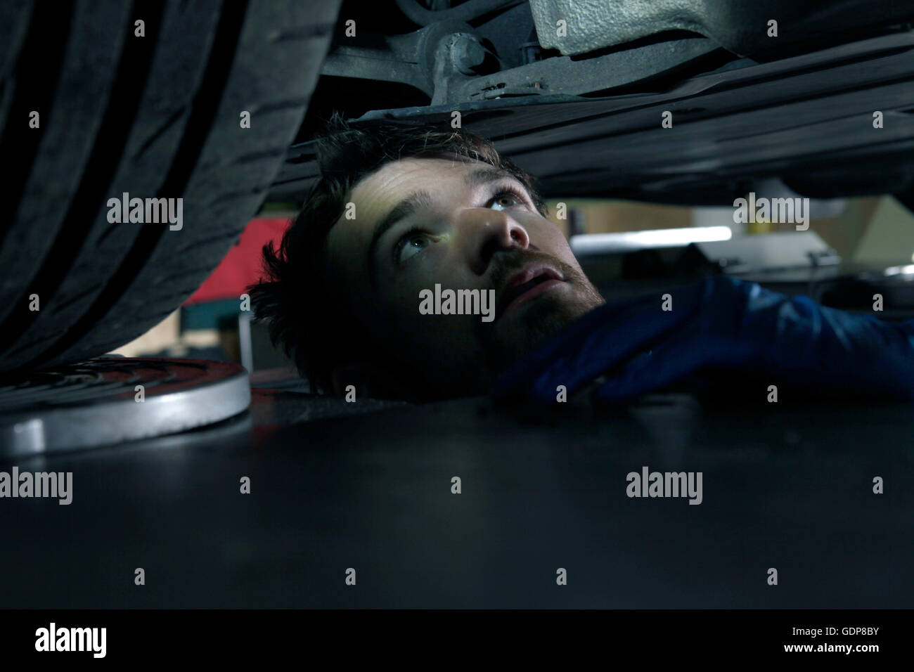 Mechaniker arbeiten unter Auto in garage Stockfoto