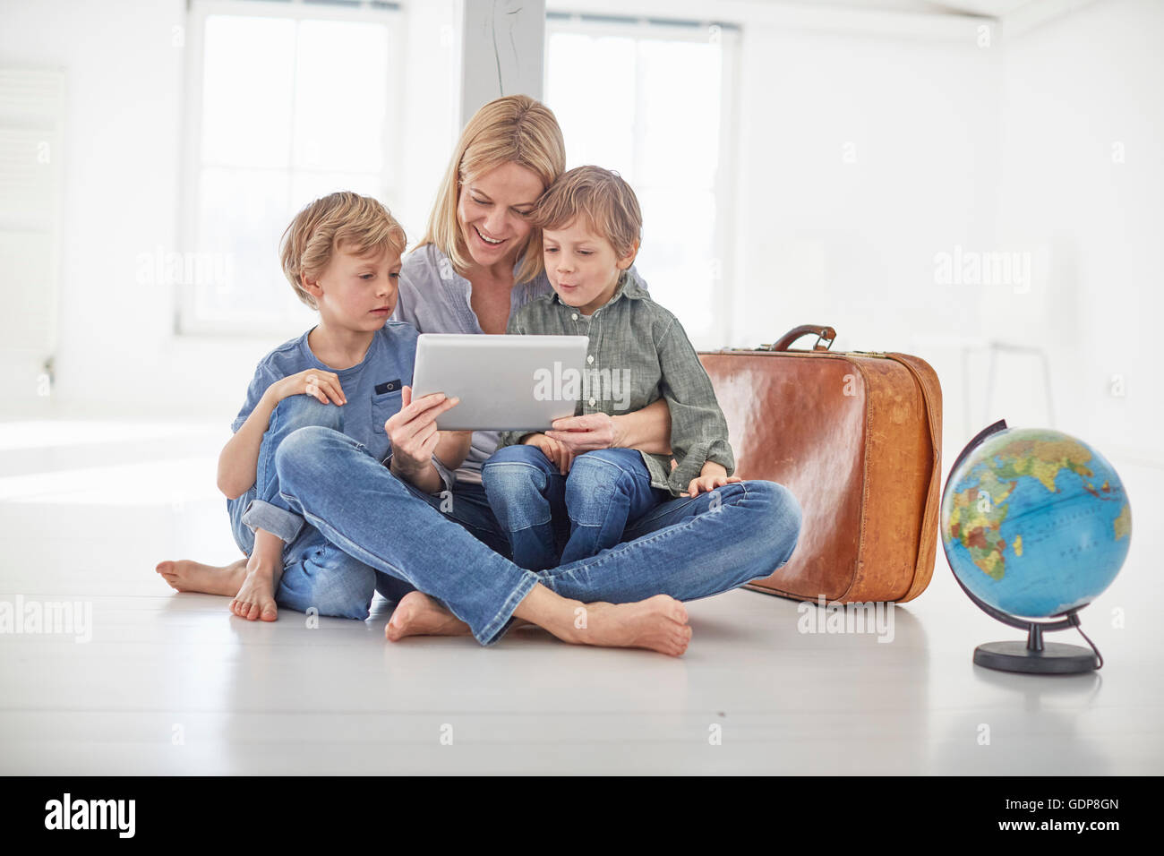 Reife Frau und zwei Sohn sitzen im Stock Blick auf digital-Tablette zusammen Stockfoto