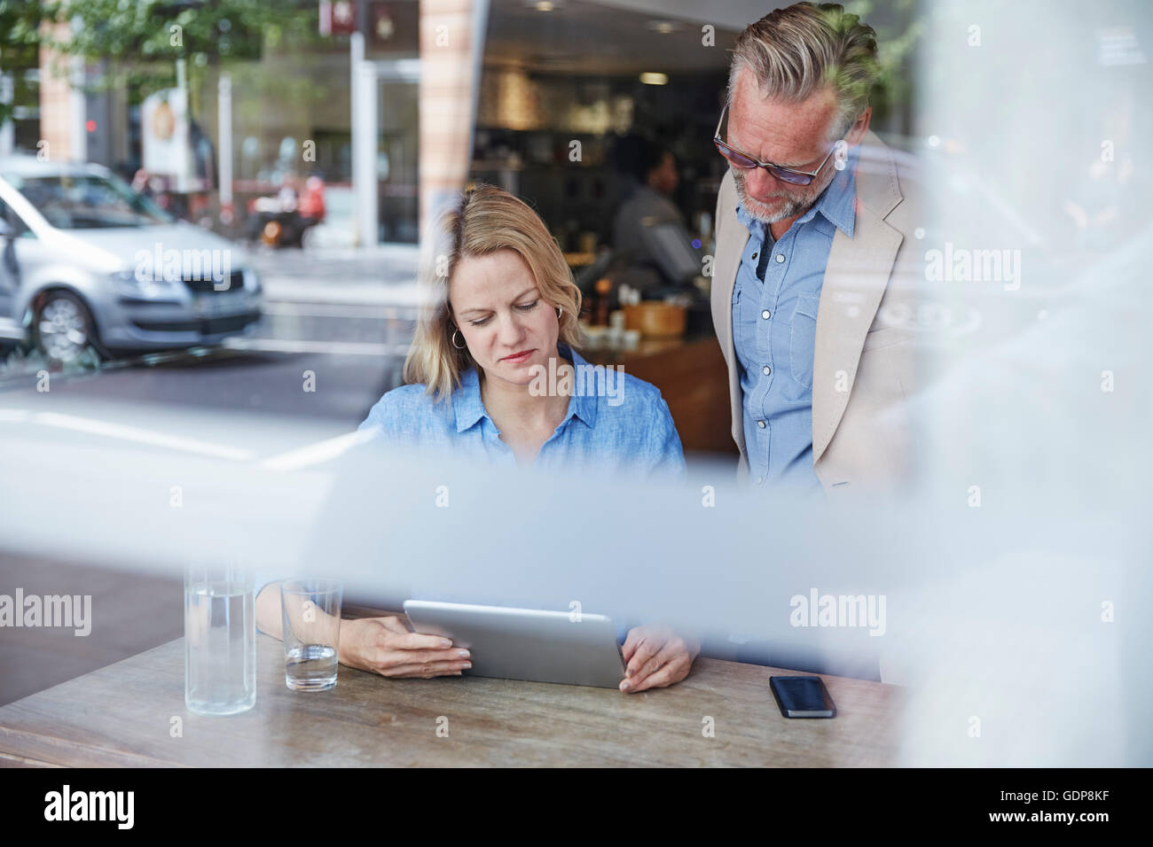 Reifer Mann und Frau in Café, digital-Tablette betrachten Stockfoto