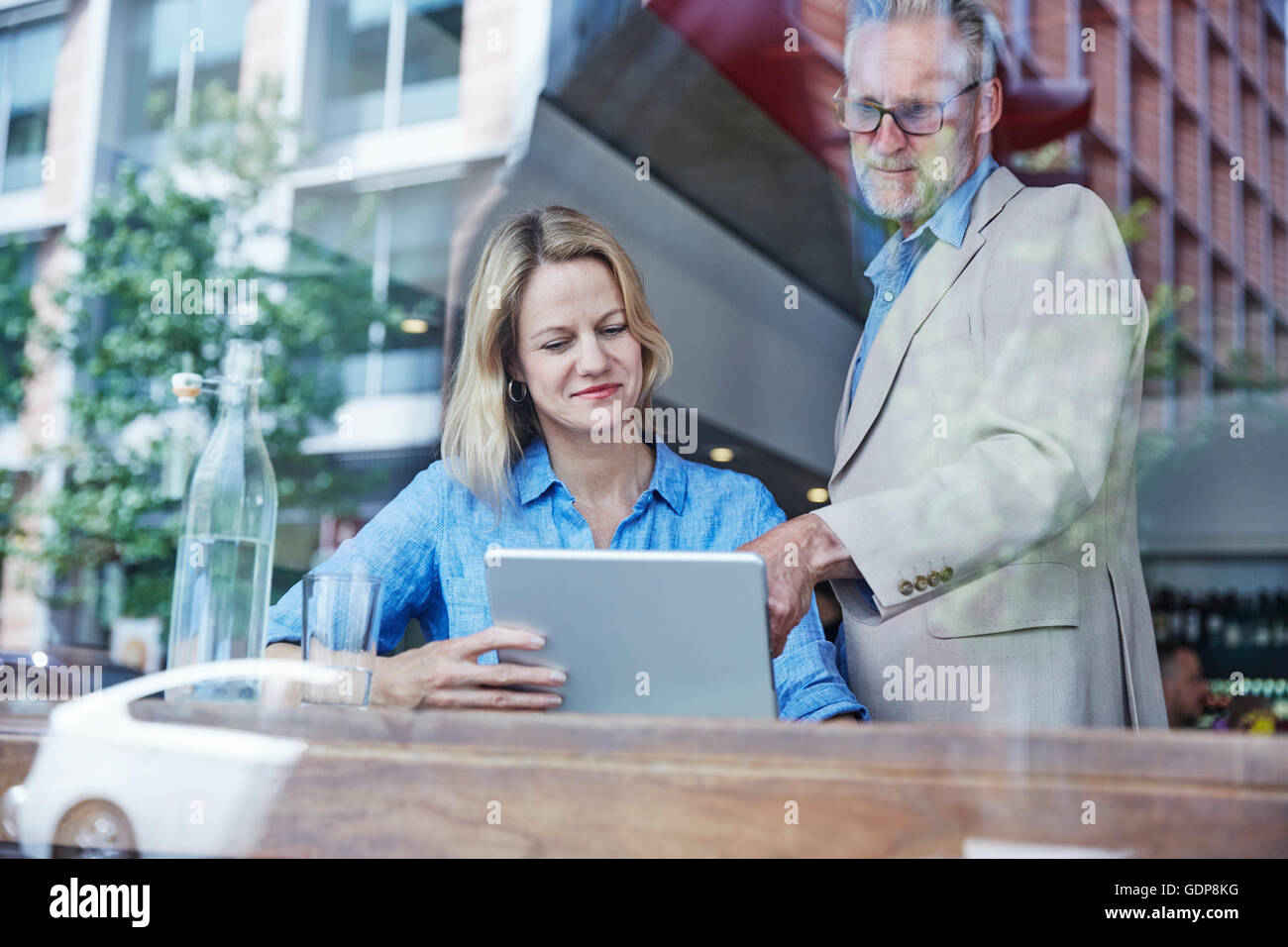 Reifer Mann und Frau in Café, digital-Tablette betrachten Stockfoto