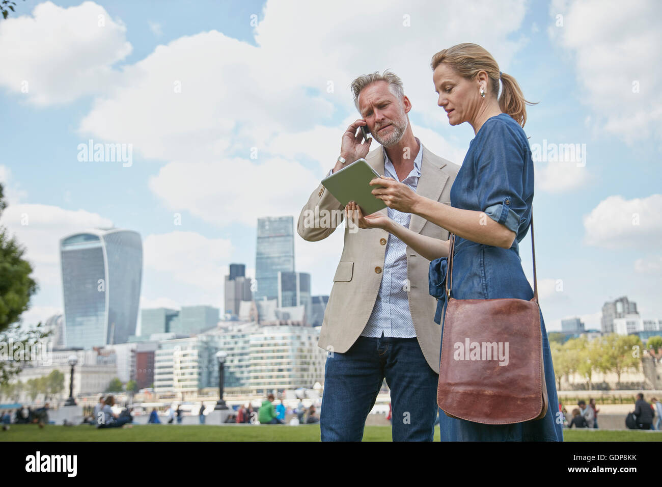 Reifer Mann und Frau im Freien, Blick auf digital-Tablette, Mann mit smartphone Stockfoto