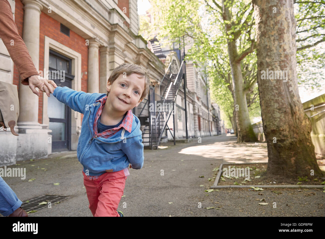 Boy Holding Mütter geben Sie Straße Blick in die Kamera Stockfoto