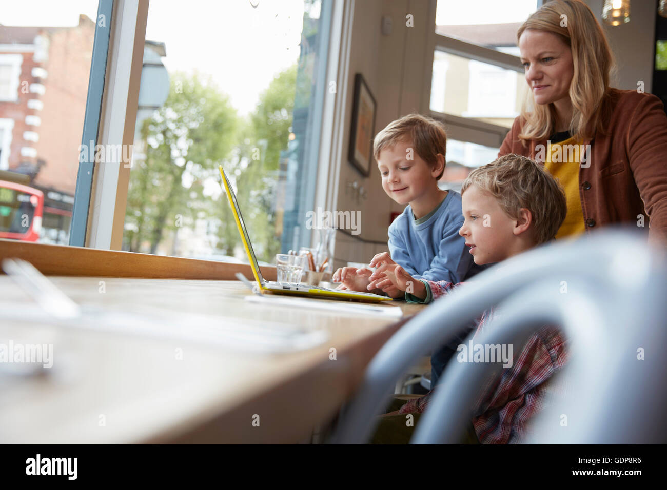 Mutter und Sohn an Fensterplatz im Café mit laptop Stockfoto