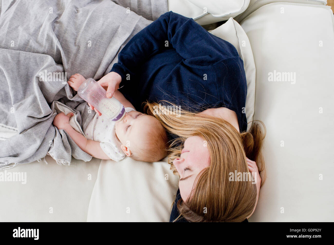 Draufsicht Mitte erwachsenen Frau Fütterung Baby Tochter auf sofa Stockfoto
