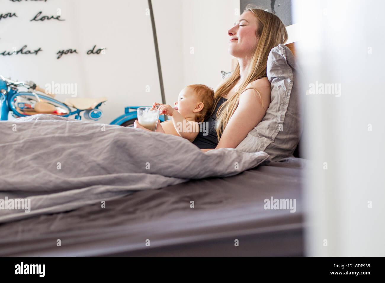 Müde, Frau und Baby Tochter liegenden Bett mit Kaffee Stockfoto