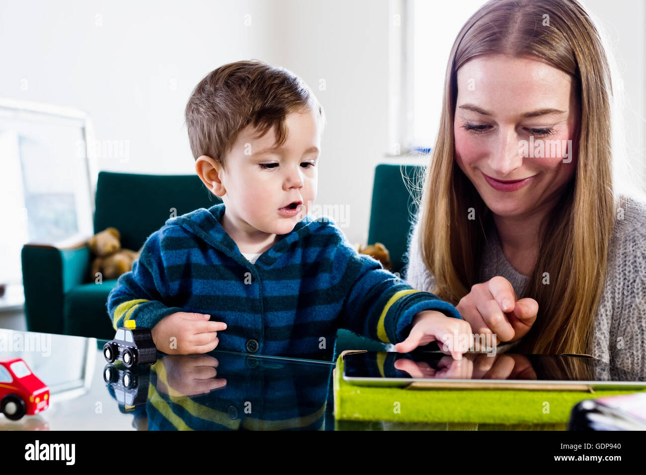 Mitte Erwachsene Frau und Baby Sohn mit Touchscreen auf digital-Tablette am Tisch Stockfoto