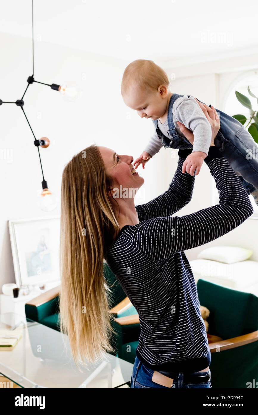 Frau mit Baby-Tochter im Wohnzimmer Stockfoto