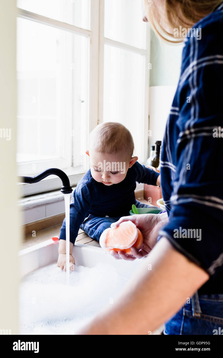 Baby Boy berühren fließendes Wasser im Spülbecken Stockfoto