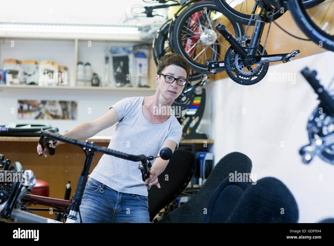 Frau in der Fahrradwerkstatt Check-Lenker am Liegerad Stockfoto