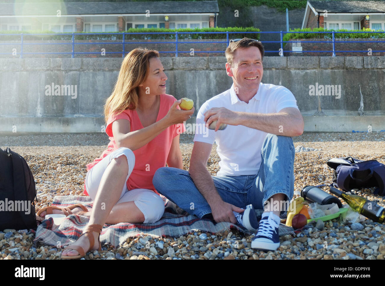 Paar mit Picknick am Kiesstrand Stockfoto